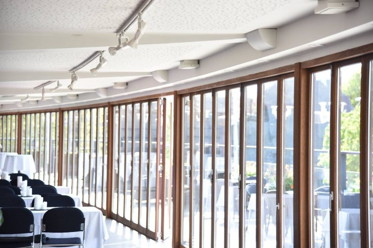 Ecklautsprecher Heller, moderner Innenraum mit großen Fenstern und Tischen.