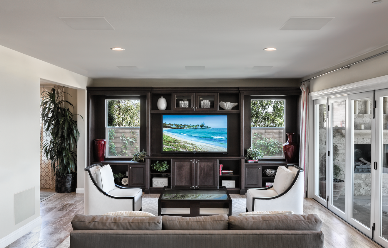 Deckenlautsprecher Modern Wohnzimmer mit Sicht auf den Strand, Fernseher an der Wand, elegante Möbel.